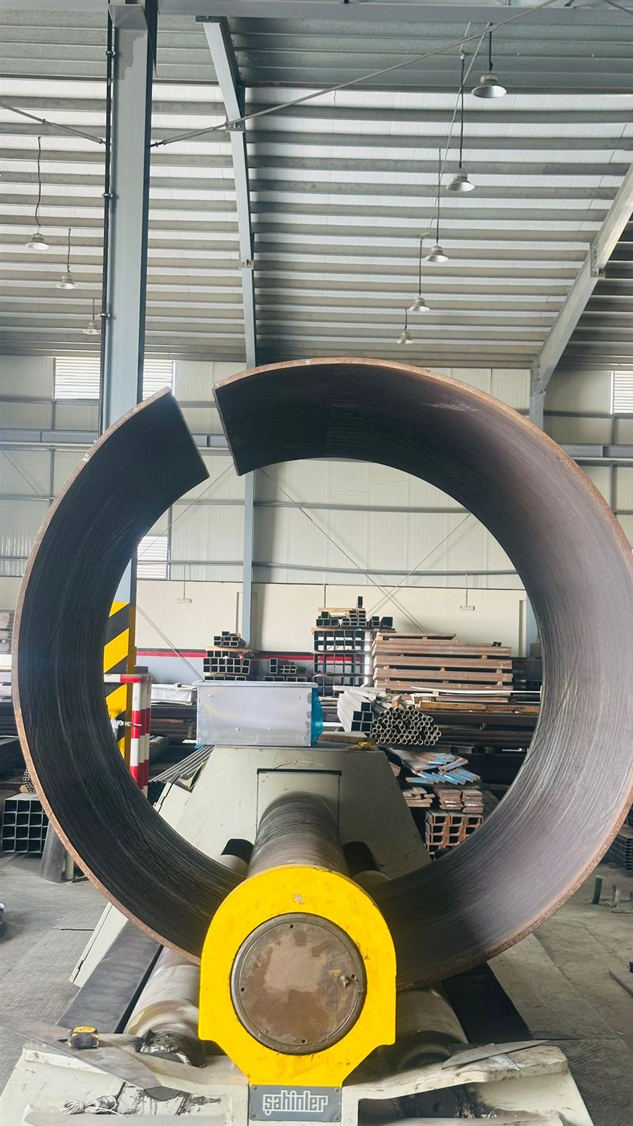 A rolled steel ring standing on the rolls, almost closed