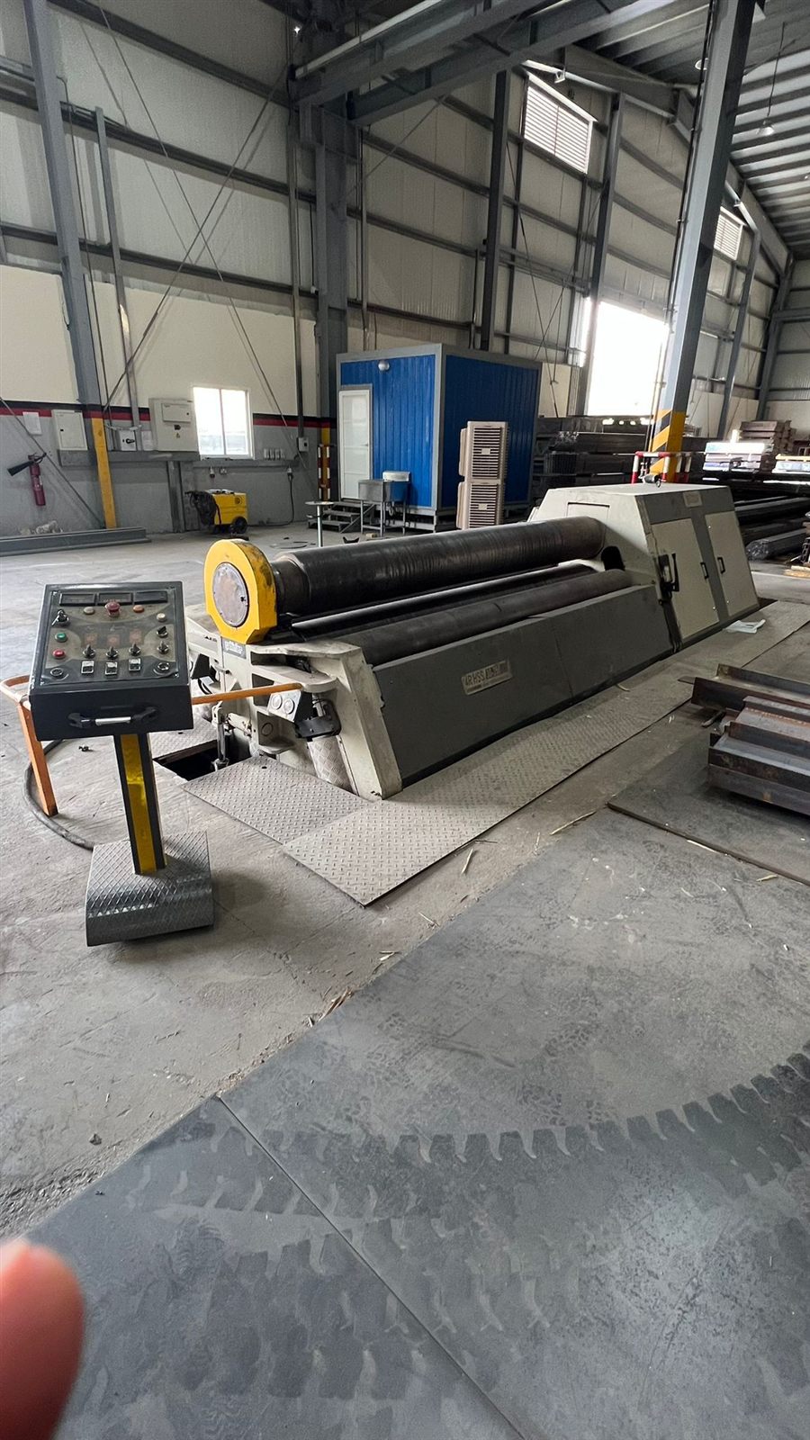 The plate rolling machine and its control pedestal on the workshop floor